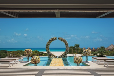 A ceremony setup near Cacun Riviera Maya beach at neighboring Dreams Playa Mujeres with turquoise waters in the background.