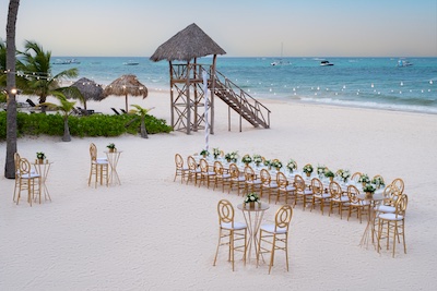 A wedding cocktail hour and reception setup for an intimate wedding on the beach in Punta Cana with turquoise water in the background at Dreams Royal Beach Punta Cana.